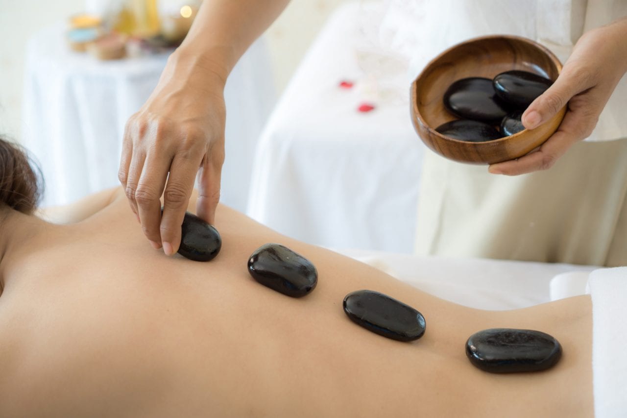 Le massage aux pierres chaudes diminue les douleurs du dos
